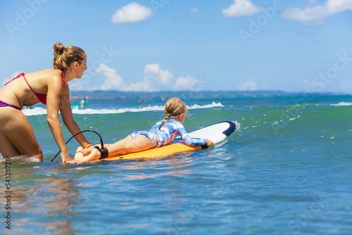 Sticker Happy baby girl - young surfer ride on surfboard with fun on sea waves