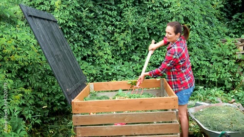 woman gardener filling compost bin for efficient farming. Composting bin with organic food waste and organic materials. Recycling concept.High quality 4k footage