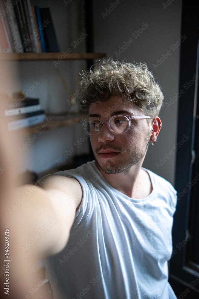 mans portrait in modern home library, taking a selfie mans portrait in modern home library, taking a selfie