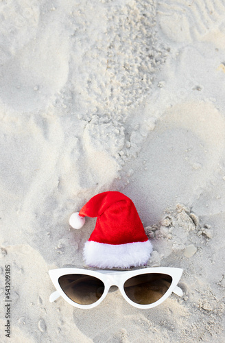 Santa Claus hat on the beach with sunglases photo