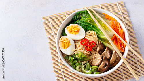 Photography Ramen noodle soup with eggs, mushrooms, pak choi in white bowl