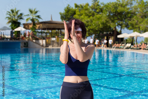 An adult female animator in a Turkish hotel pool with clear water.