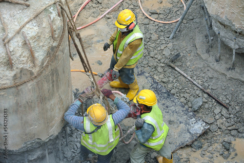 JOHOR, MALAYSIA -JANUARY 13, 2015: A construction workers cutting foundation pile using hacking method at the construction site. He using the heavy duty mobile hacker machine.  