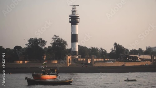 Lighthouse and Boats on the shore of Arabian sea at Daman , India photo