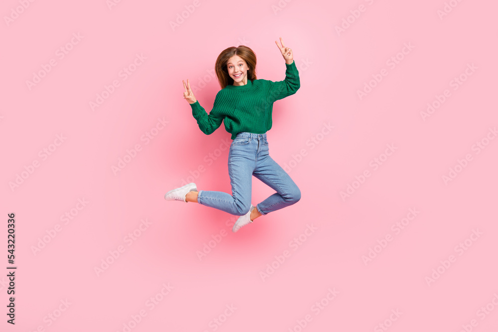 Full length photo of funky charming girl dressed knitted pullover showing v-signs jumping high isolated pink color background