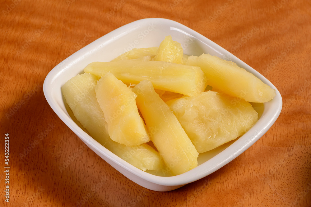 Manioc. Small portion of cooked cassava in white bowl on wooden table. Manioc. Small portion of cooked cassava in white bowl on wooden table.