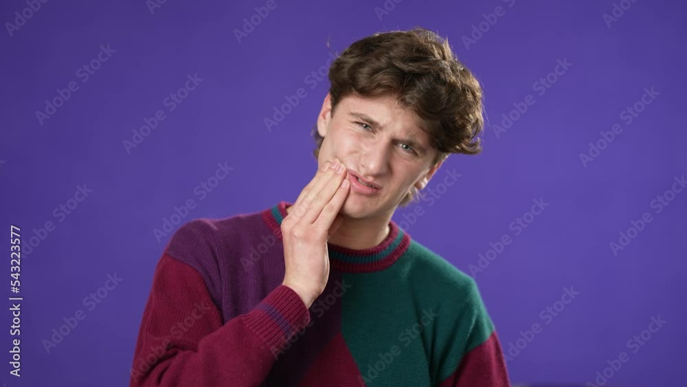 Portrait of young hipster man 20s with tooth dental ache pain problem in mouth isolated on purple background in studio Portrait of young hipster man 20s with tooth dental ache pain problem in mouth isolated on purple background in studio