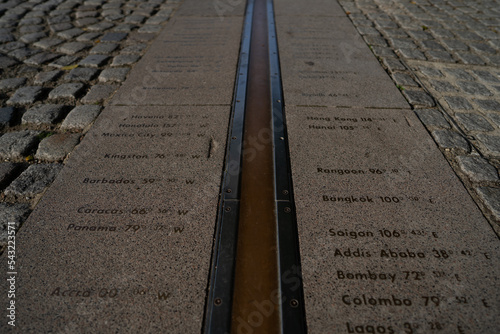 Prime meridian on paved road photo