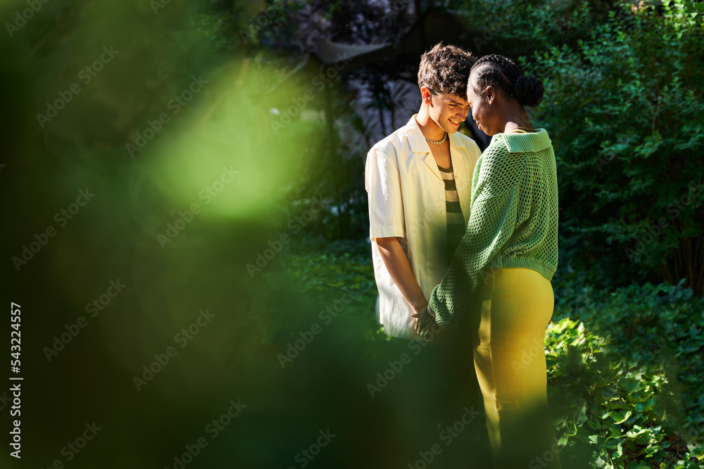Multiethnic couple touching foreheads during date Multiethnic couple touching foreheads during date
