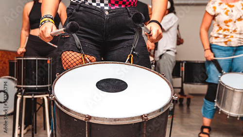 Unrecognizable woman with maces in her hands plays a drum
