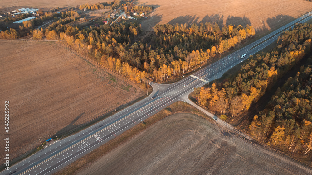 Aerial view of intercity road with fast driving cars at sunset. Top view from drone of highway traffic in evening