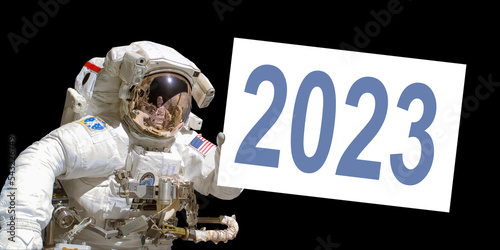 Astronaut in space holding a 2023 white  board - elements of this image are provided by NASA photo
