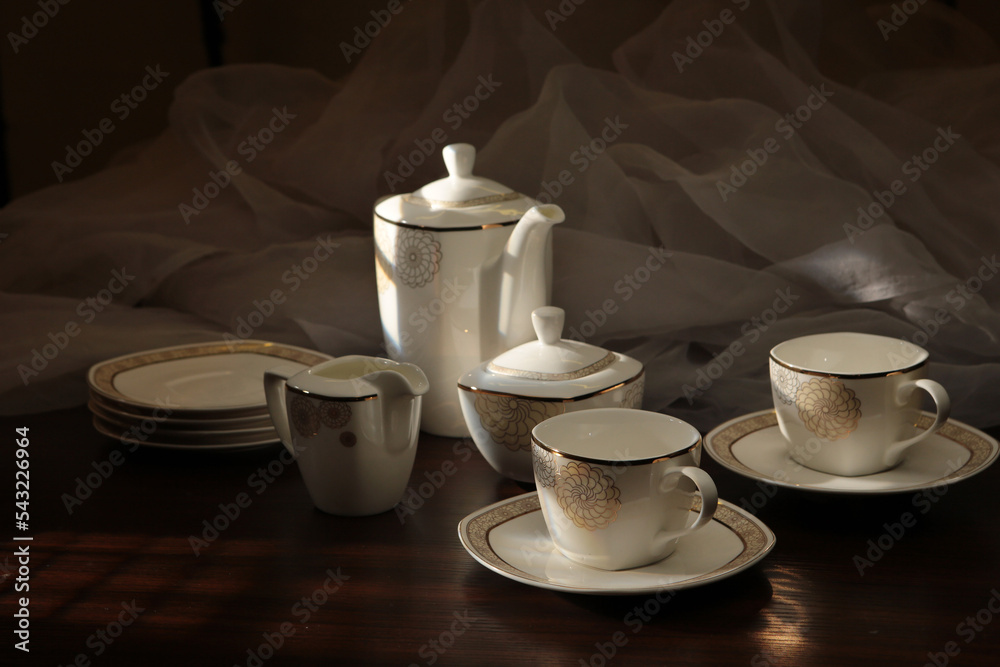 Fototapeta premium White tea set on a white background. Teapot, cups, plates