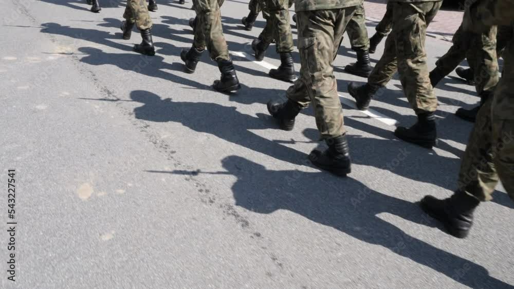 Shadows of marching soldiers on the street.