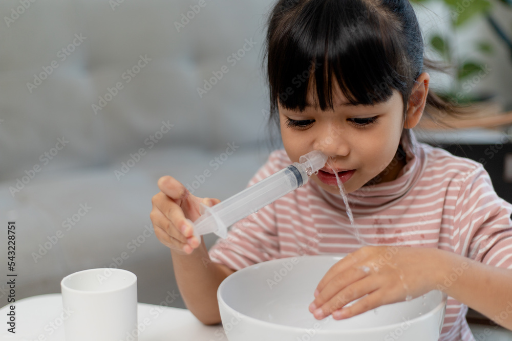 Little asian girl saline nasal wash nose at home. Little asian girl saline nasal wash nose at home.