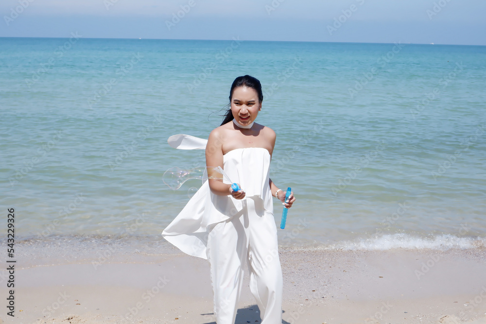Girl blowing soap bubbles playing on the beach travel concept. Girl blowing soap bubbles playing on the beach travel concept.