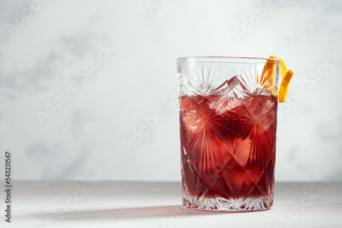 Negroni cocktail in a rocks glass with orange peel on a white background.