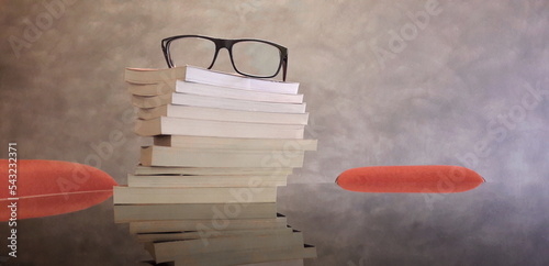 Un paio di occhiali da vista e alcuni libri sulla scrivania di uno studente universitario photo