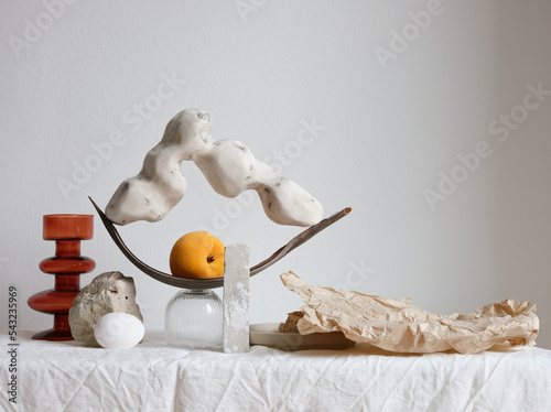 Arrangement with handmade sculpture and a peach