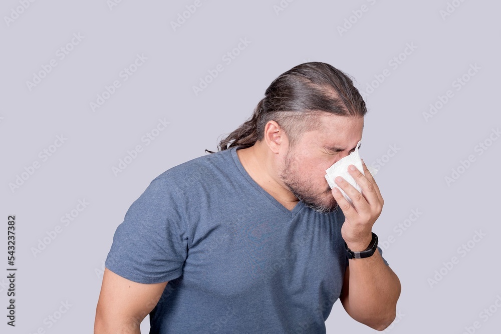 A man blows his nose forcibly into a tissue paper. Dealing with a cold, rhinitis or allergy. A man blows his nose forcibly into a tissue paper. Dealing with a cold, rhinitis or allergy.