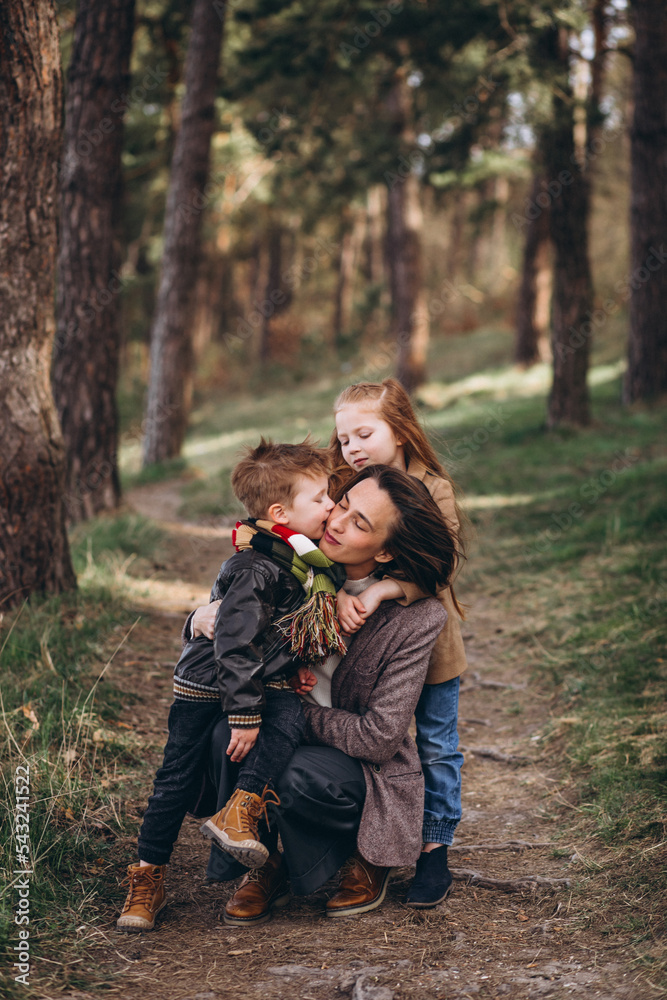 Young mother with daughter and son in forest Young mother with daughter and son in forest