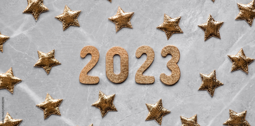 Banner. Happy New Year. Gold numbers 2023 and gold stars on a fashionable gray marble background. Flat lay. Banner. Happy New Year. Gold numbers 2023 and gold stars on a fashionable gray marble background. Flat lay.