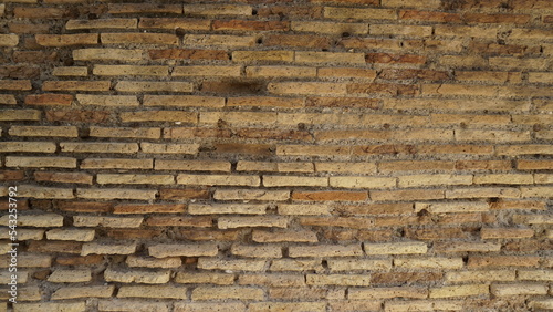Detail of a wall in Roman structure made of bricks and with the opus reticulatum technique in blocks of porphyry, in the archaeological site of Ostia Antica.