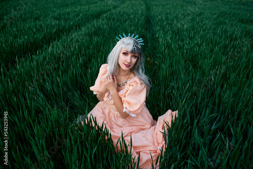 Girl in a dress in a yellow-green field photo