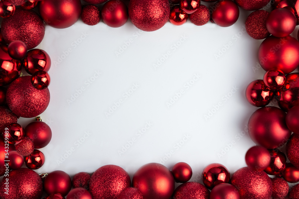 Framing of red Christmas balls of different sizes and textures on a white background Framing of red Christmas balls of different sizes and textures on a white background