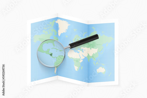 Enlarge Nicaragua with a magnifying glass on a folded map of the world.