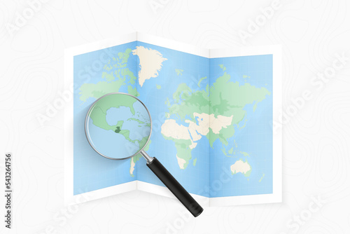 Enlarge Guatemala with a magnifying glass on a folded map of the world.