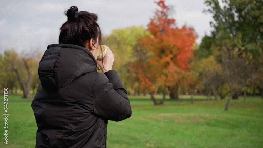 Girl in an autumn park with a glass of hot morning espresso coffee. Time to warm up. Walk in the forest and autumn relaxation. Takeaway coffee concept. Girl in an autumn park with a glass of hot morning espresso coffee. Time to warm up. Walk in the forest and autumn relaxation. Takeaway coffee concept.