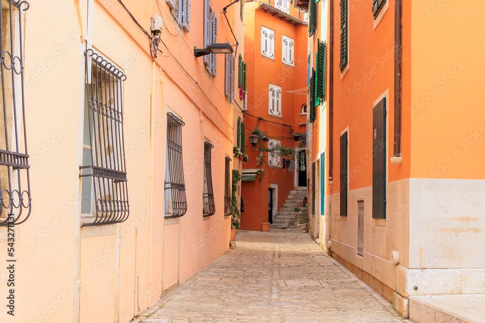 Fototapeta premium Old town alley in the Croatian town of Rovinj with old residential building fronts and freely laid power cables