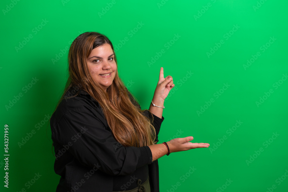 Young woman, posing and showing with hands, on Green Background Young woman, posing and showing with hands, on Green Background