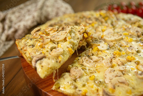 Fatia de pizza sendo retirada com queijo mussarela, champignons, milho verde, azeitonas. Close-up e foto seletivo photo