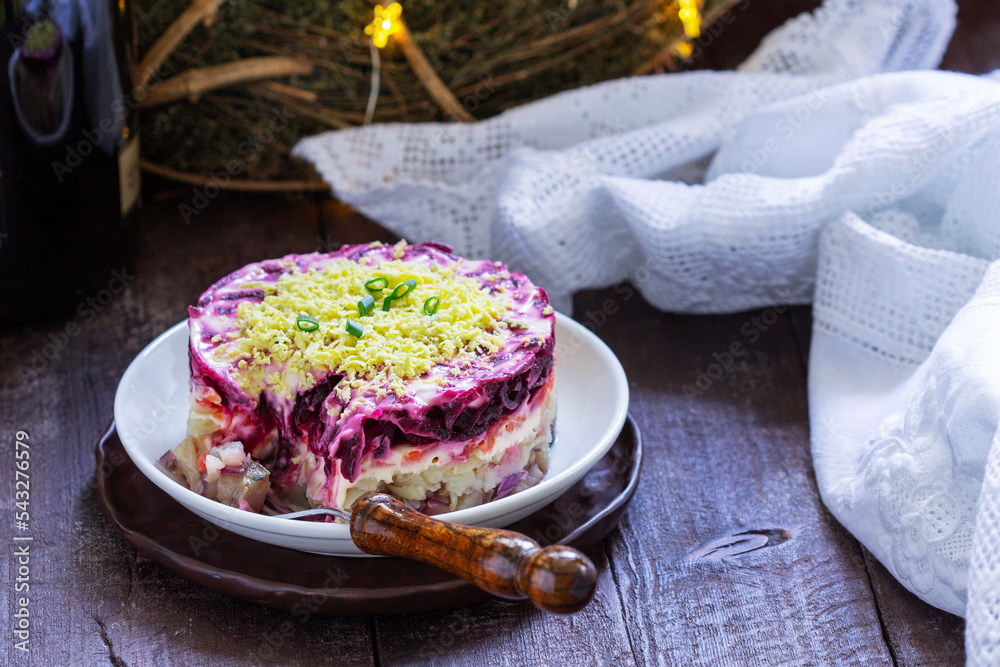 Dressed herring, raditional Soviet festive salad of herring and vegetables in a New Year's decoration.