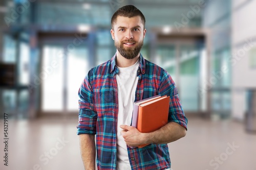 Happy male student standing near college