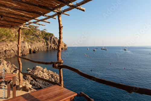 Restaurante al borde del mar en Cala Deià (Mallorca). Vista al mar desde las mesas de madera. photo