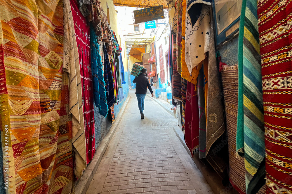 Traditional Moroccan carpets hanging on the street marketplace in the medina of Fez