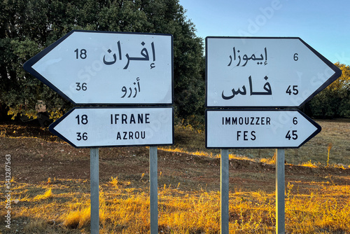 Signpost showing directions of Fes, Immouzzer, Ifrane and Azrou on the roadside photo