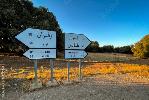 Signpost showing directions of Fes, Immouzzer, Ifrane and Azrou on the roadside photo