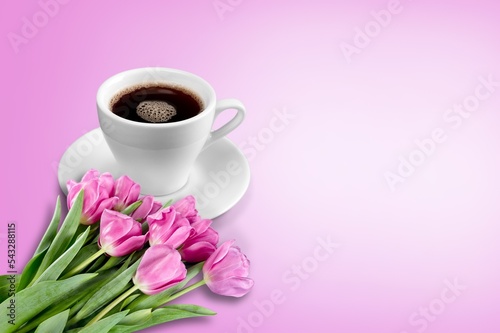Fresh flowers and coffee cup on pastel background.
