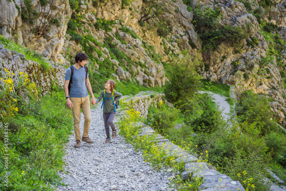 family travel - father and son hiking in mountains of Montenegro, Kotor