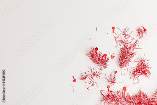 flatlay of christmas party with red streamers on white background, top view