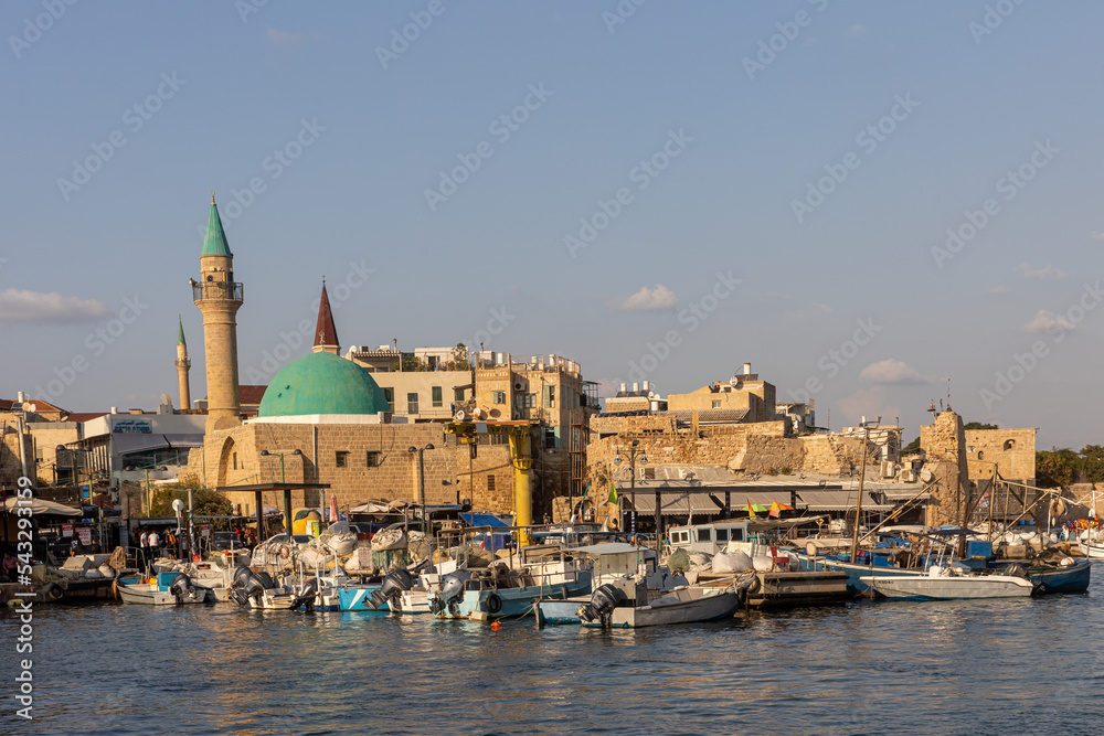 Acre, Israel - November 01, 2022, Colorful view from mediterranean sea on Old CIty and Port of Akko, Israel - Mosque Domes,minarets and mooring of a tourist boats in a sunny day