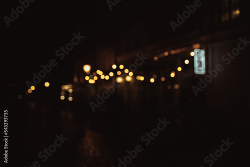 Blurred image of the cafe terrace interior with garland lights. Abstract image. © Shi 