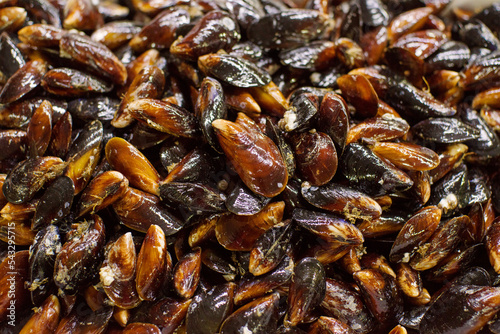 Fresh sea mussels on the counter at the fish market. © isavira