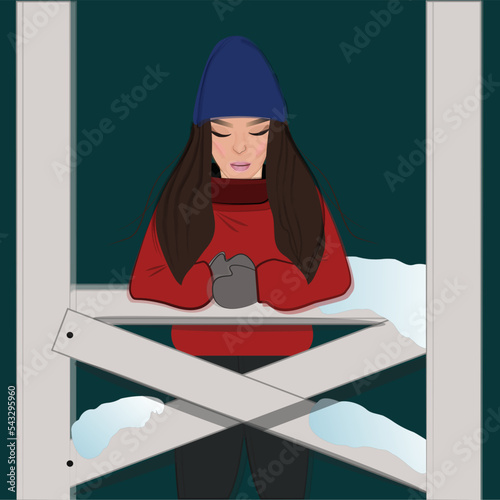 A girl in winter in a gazebo with coffee,with a snowy evening