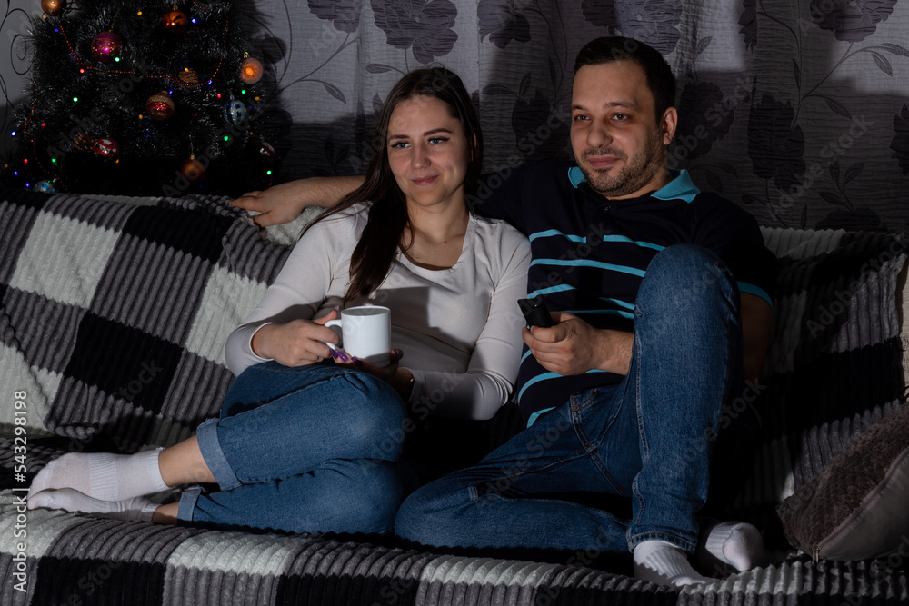 Couple while watching TV. Selective focus. Images for articles about movies, hobbies, leisure. Couple while watching TV. Selective focus. Images for articles about movies, hobbies, leisure.