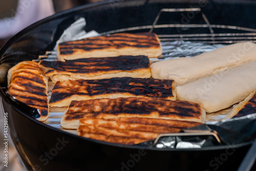 Process of cooking doner kebab on grill at summer local food market - close up. Outdoor cooking, barbecue, gastronomy, cookery and street food concept photo